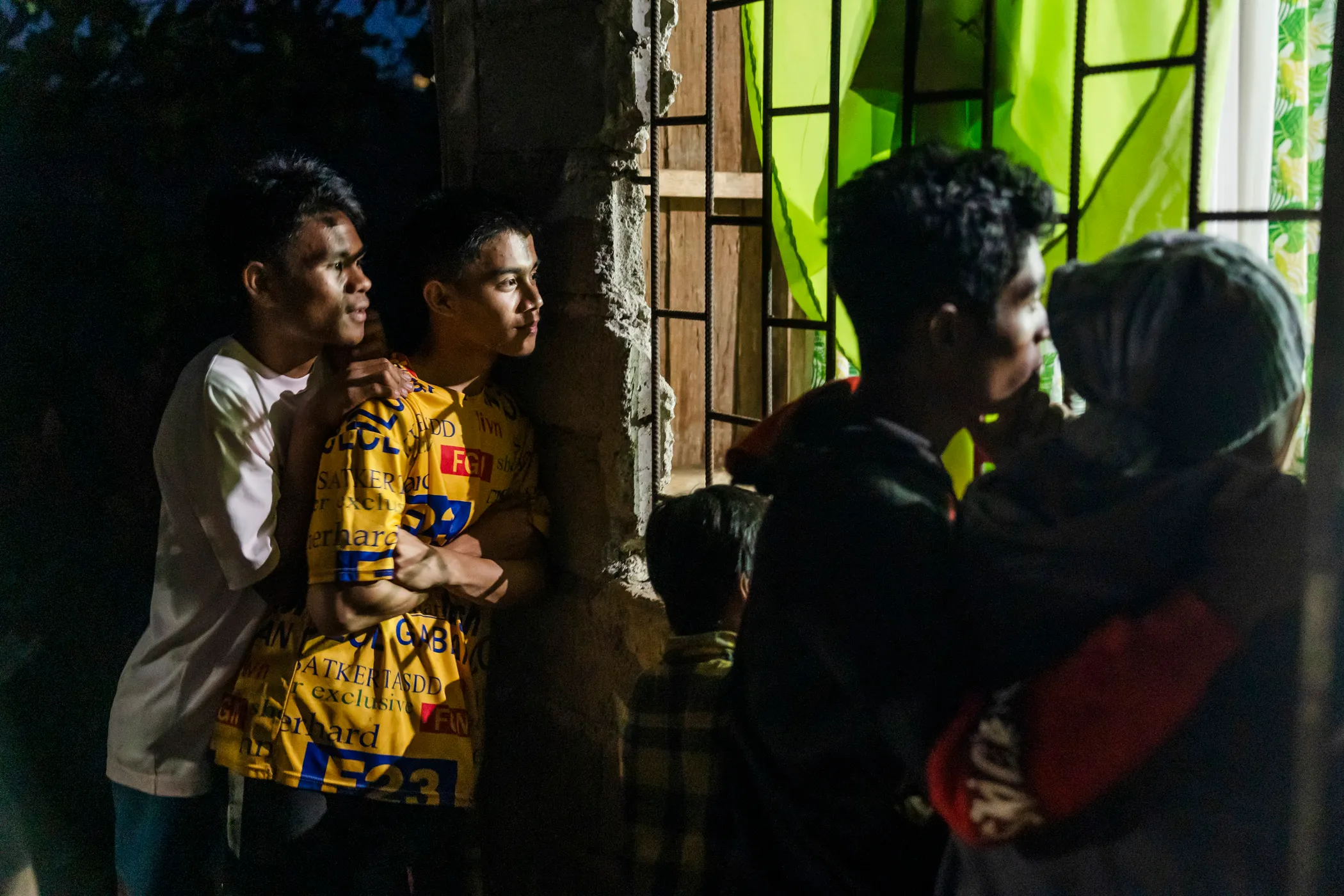Curious onlookers gather to listen as a church service extends into the evening.