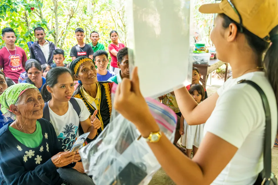 A ministry volunteer holds up a primer on how to use the various functions of the Messenger audio Bible.